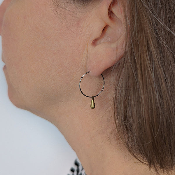Titanium hoops with brass teardrop charms